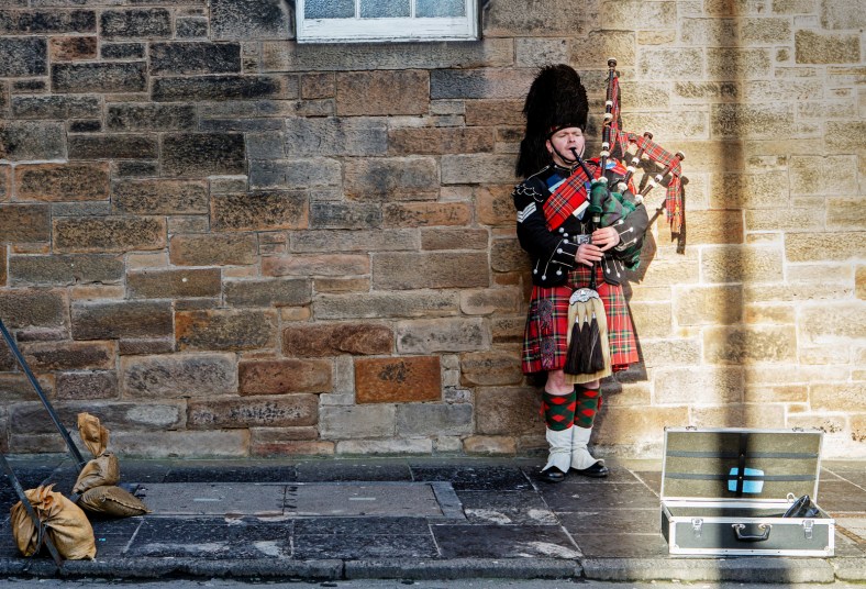 Un gaitero voluntario en la explanada del castillo. Parte de lo que reciben lo donan a caridad.